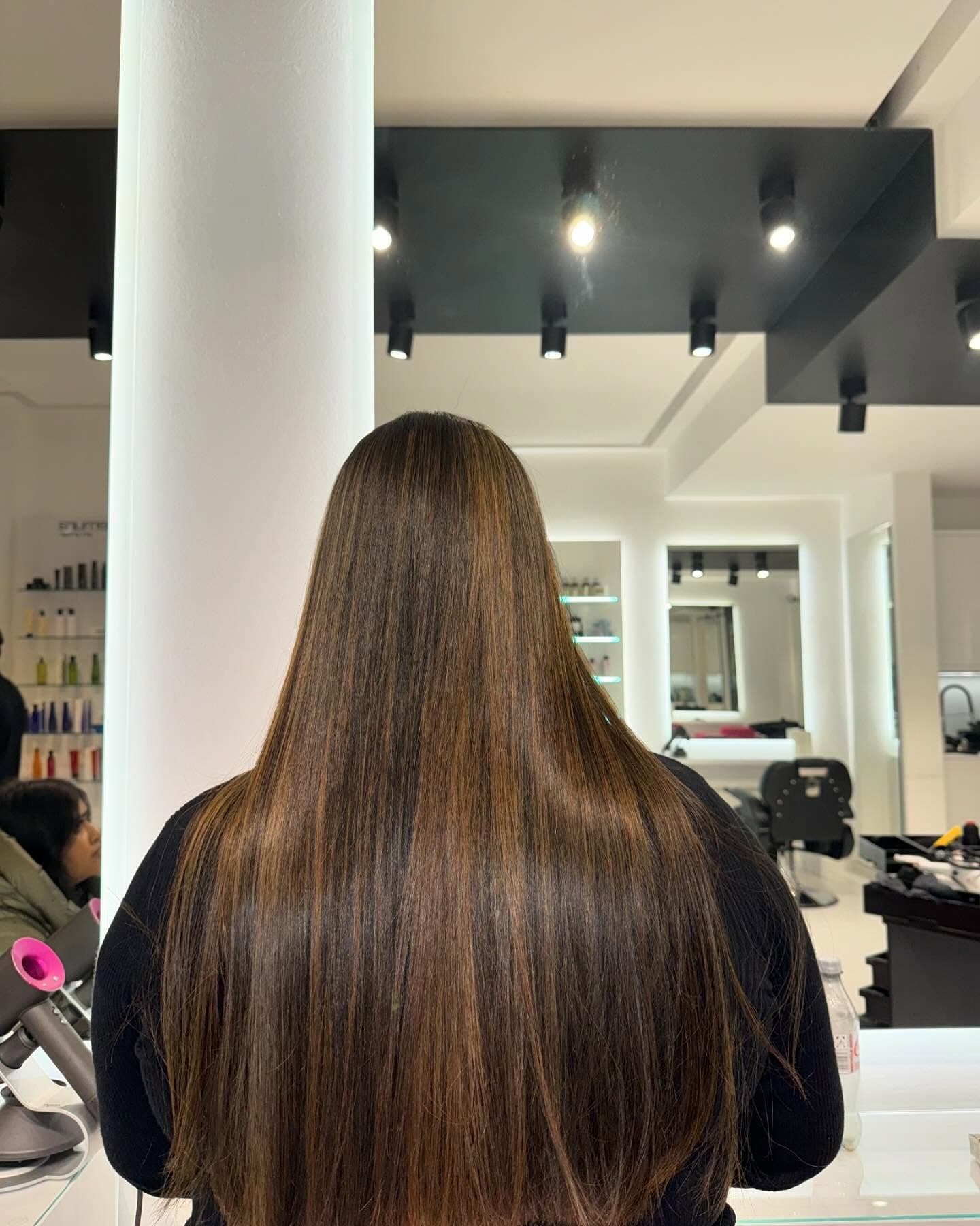 Lange, glatte brünette Längen mit Balayage, Rückansicht im Salon