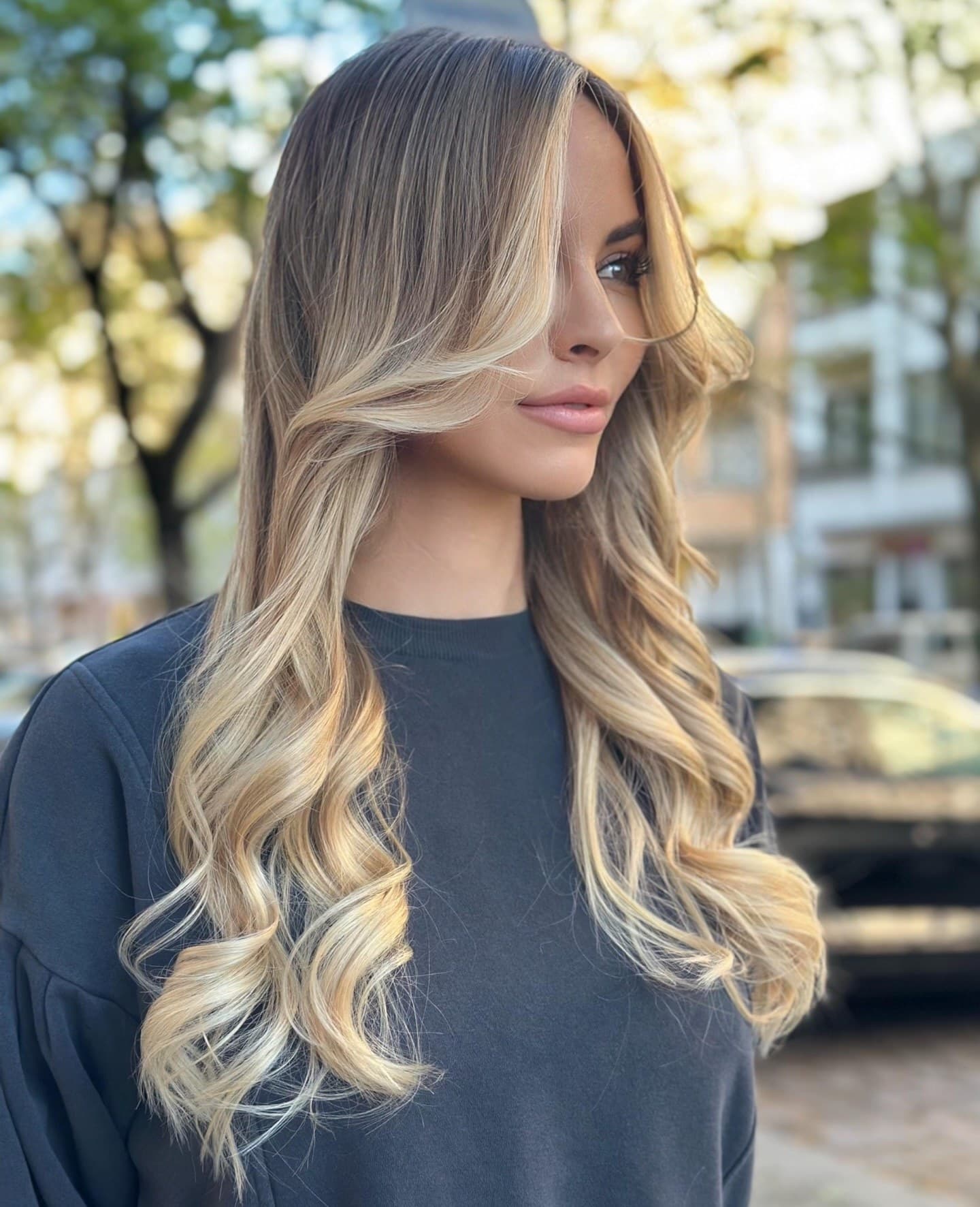 Lange blonde Balayage-Wellen, Porträt im Freien