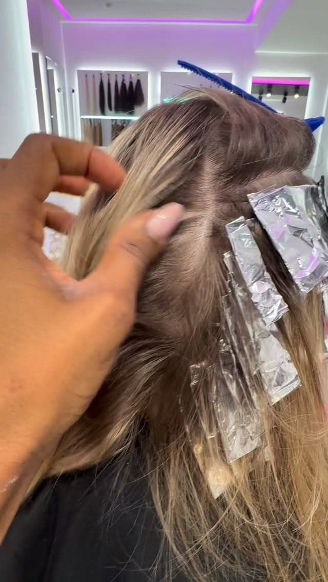 Strähnen in Folie, eine Hand teilt das Haar ab